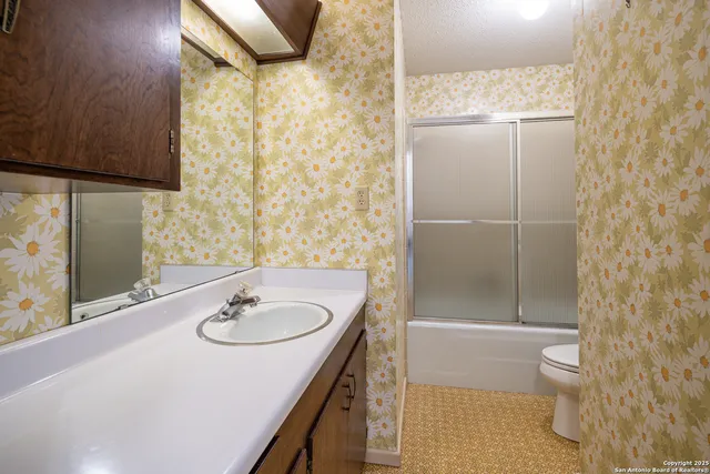 a bathroom with a sink toilet and shower