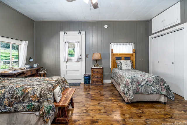 a spacious bedroom with a bed and a flat screen tv