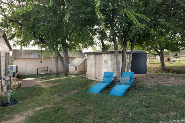 a view of a house with backyard and sitting area