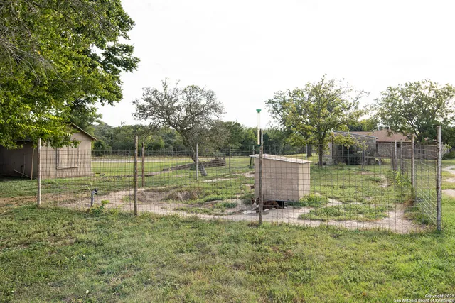 a view of a backyard with wooden fence