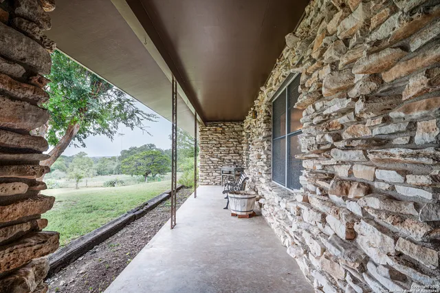 a view of a porch with chairs and backyard of the house