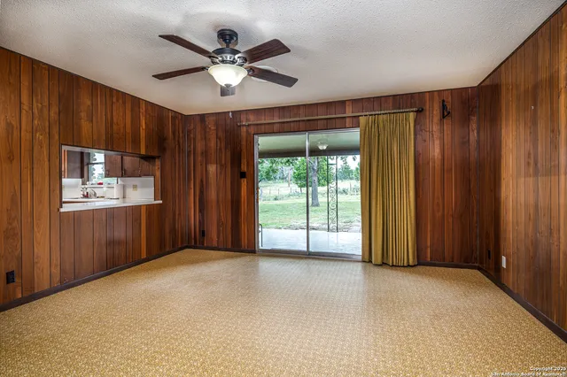 a view of a livingroom with a ceiling fan and window