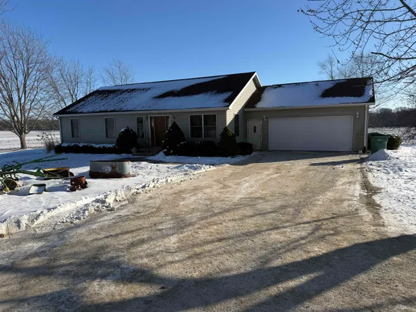 a front view of house with yard covered in snow