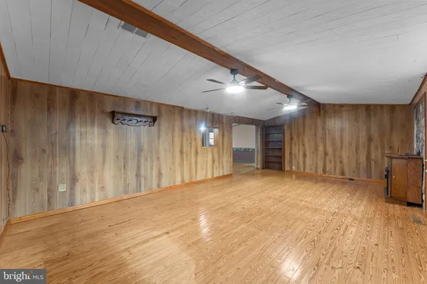 an empty room with windows and fan