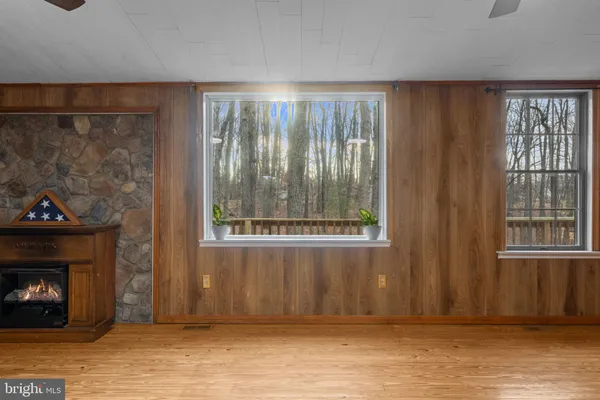 a view of n empty room with window and wooden floor