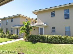 2096 Alamanda Drive, Unit 102 Naples, FL 34102 - Photo 19 of 23 a front view of a house with a yard