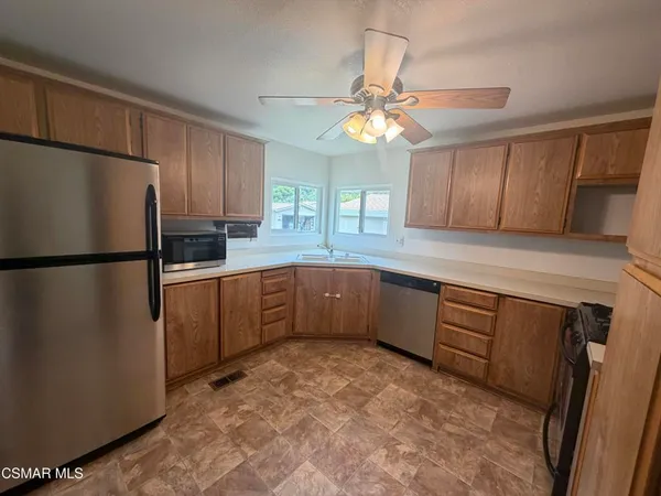 a kitchen with a refrigerator a sink and cabinets