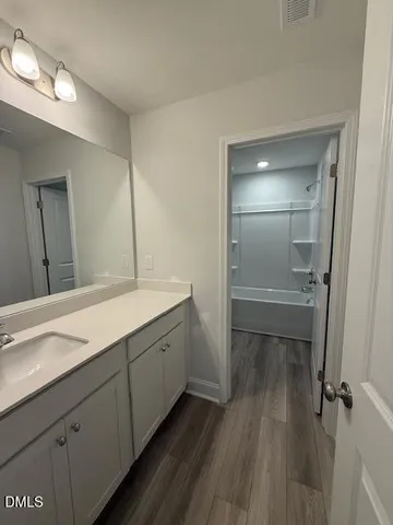a bathroom with a sink mirror and a toilet