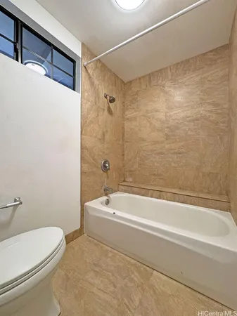 a bathroom with a white toilet sitting next to a bathtub