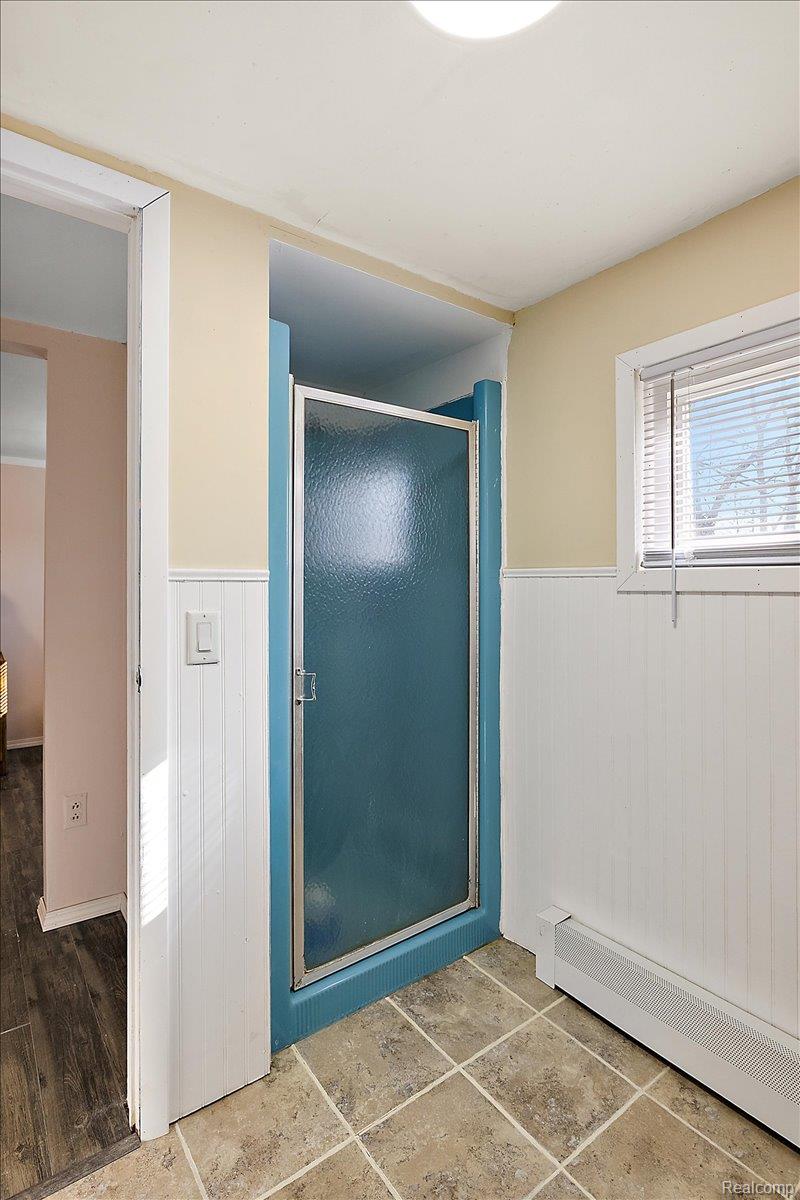 4705 Ketchum Road St. Clair, MI 48079 - Photo 40 of 58 Bathroom with baseboard heating, a stall shower, and a wainscoted wall