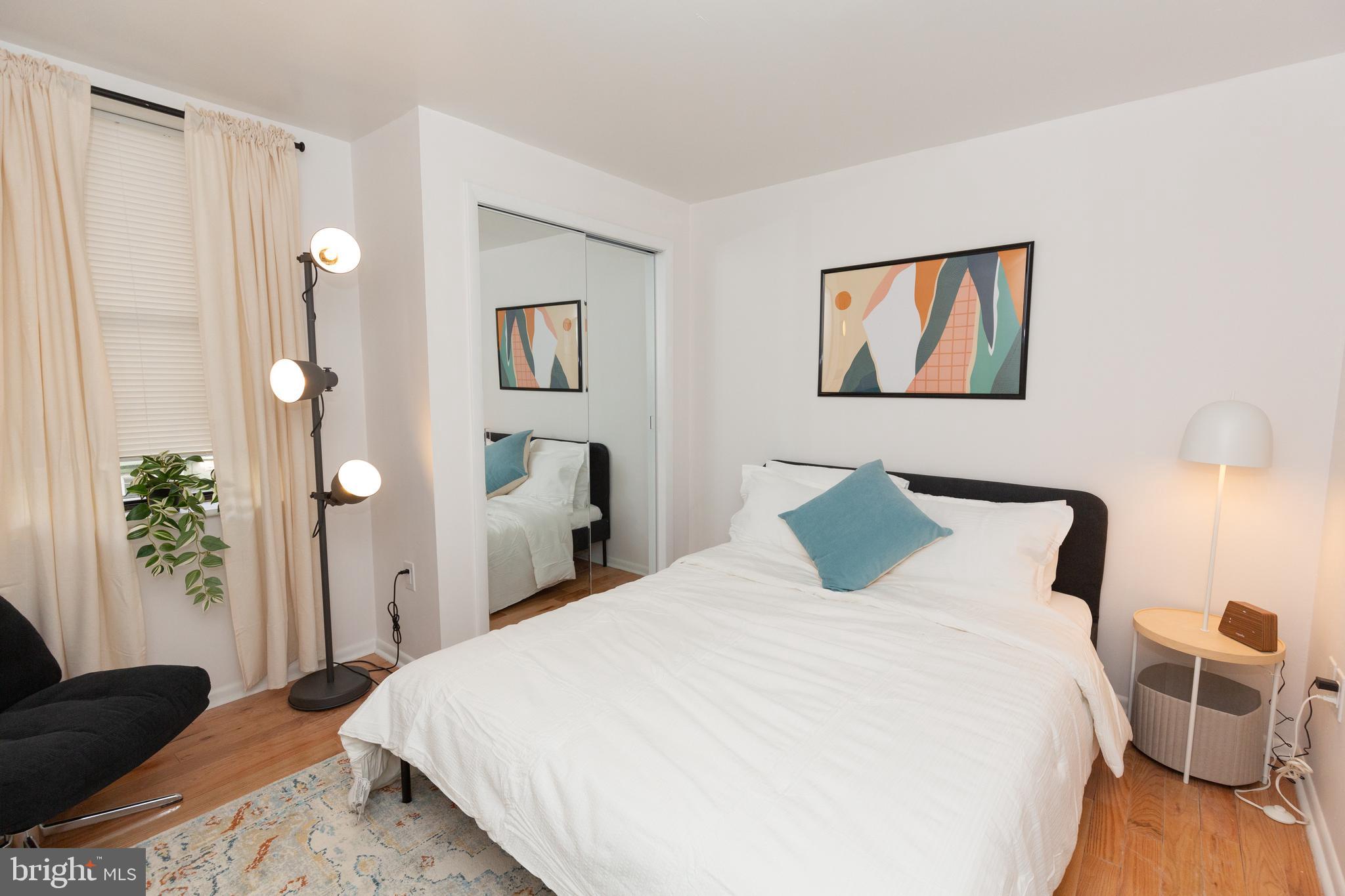 1915 Pemberton Street, Unit 2 Philadelphia, PA 19146 - Photo 13 of 16 a bedroom with a large bed and a chandelier