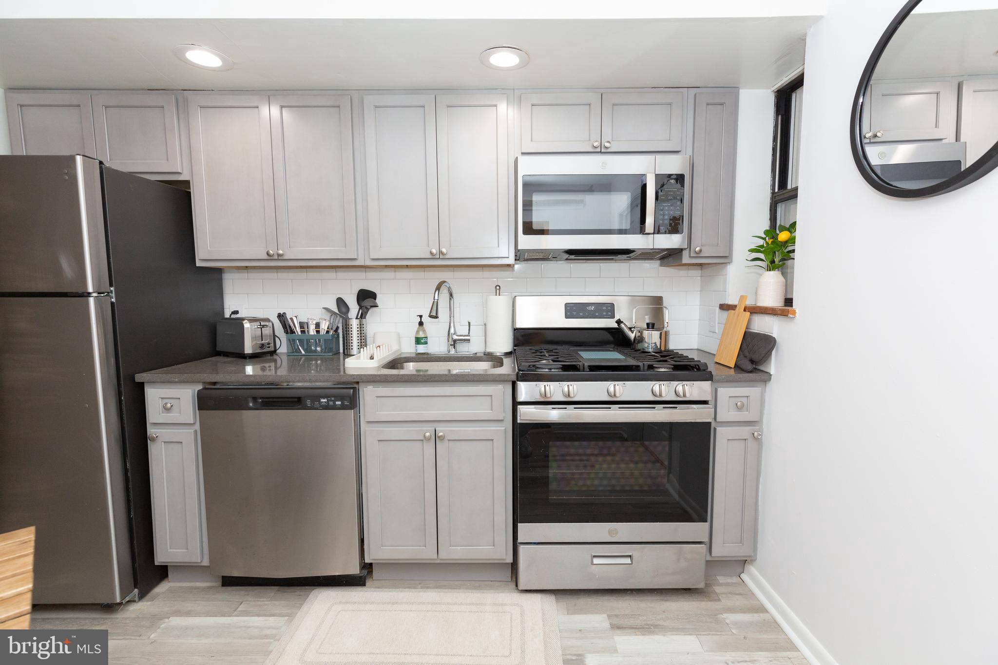 1915 Pemberton Street, Unit 2 Philadelphia, PA 19146 - Photo 7 of 16 a kitchen with stainless steel appliances granite countertop a stove a refrigerator and a microwave