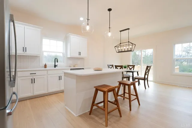 a kitchen with stainless steel appliances granite countertop a sink a stove a refrigerator and island with wooden floor