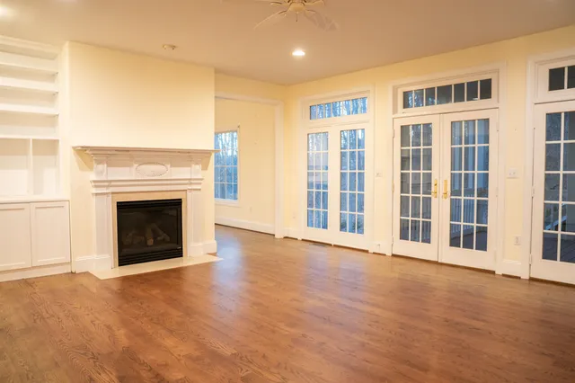 a spacious bedroom with a bed and a flat tv screen on the dresser