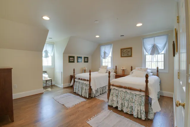 a bedroom with two beds and painting on the wall