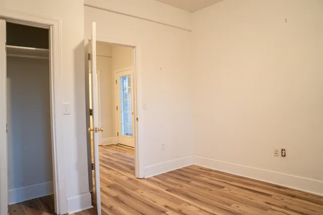 a view of a livingroom with wooden floor and a window
