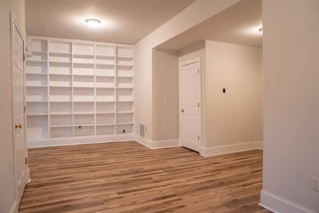 a view of empty room with wooden floor