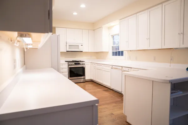 a kitchen with stainless steel appliances a white stove top oven sink and cabinets