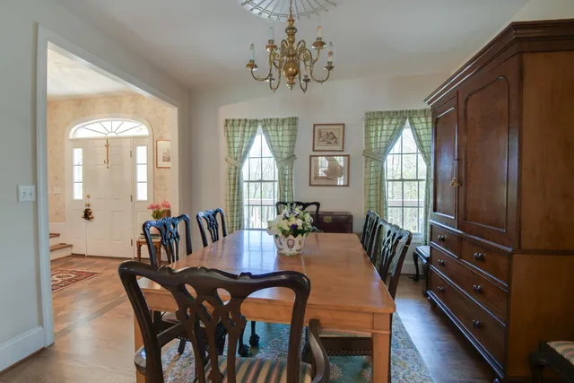 a view of an empty room with wooden floor fireplace and a window
