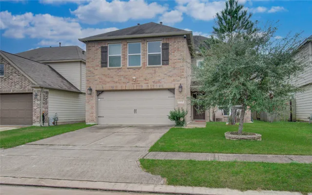 a front view of a house with a yard and garage