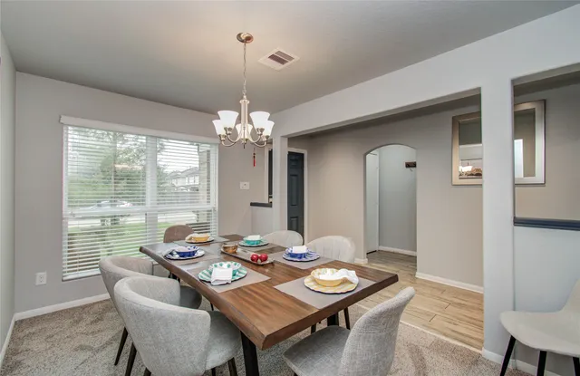 a view of a dining room with furniture and chandelier