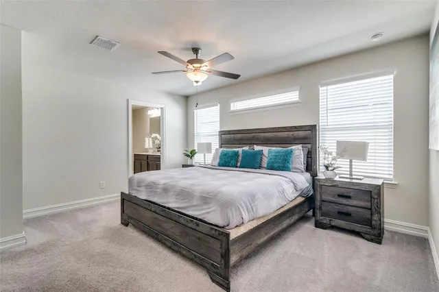 a spacious bedroom with a bed and a chandelier