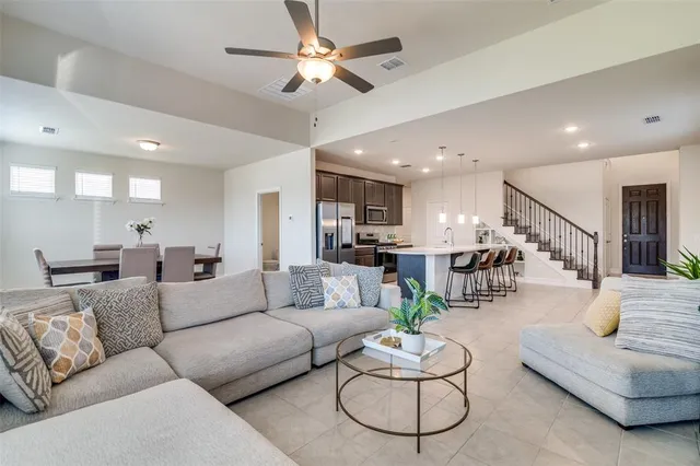 a living room with furniture kitchen view and a chandelier