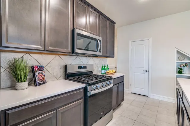 a kitchen with stainless steel appliances a sink stove and cabinets