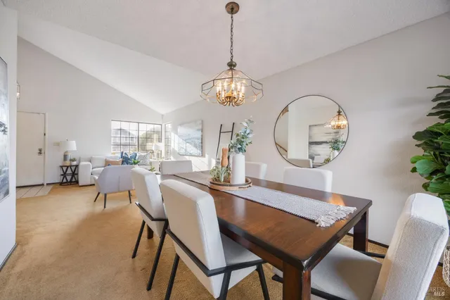 a view of a dining room with furniture a chandelier and wooden floor