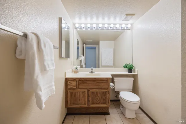 a bathroom with a granite countertop sink a toilet and shower