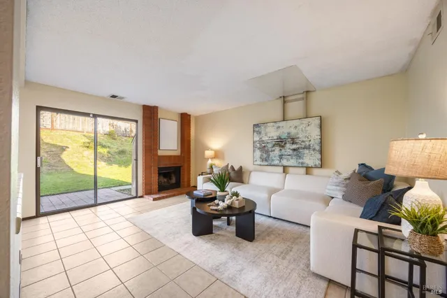 a living room with furniture large window and a fireplace