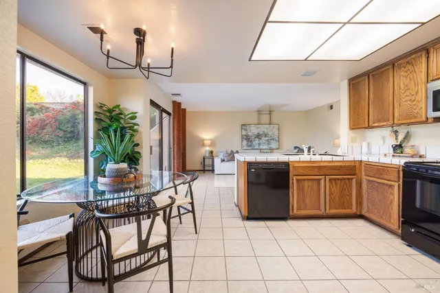 a kitchen with stainless steel appliances granite countertop a stove a sink dishwasher and a refrigerator with wooden cabinets