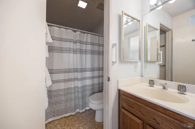 a bathroom with a sink toilet vanity and shower