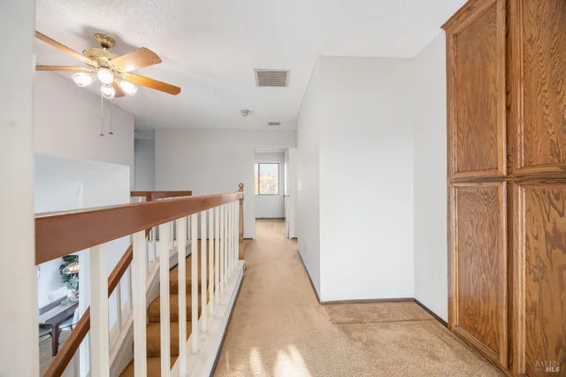 a view of a hallway with wooden floor and staircase