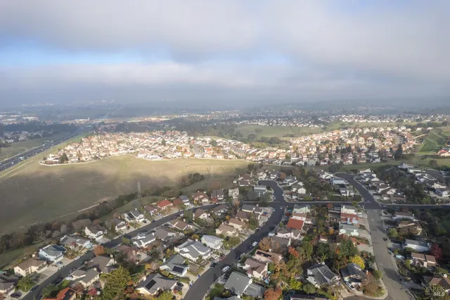 an aerial view of ocean and residential houses with outdoor space