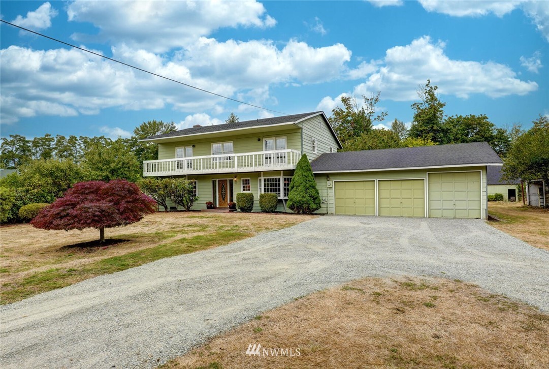 a view of a house with a yard and potted plants