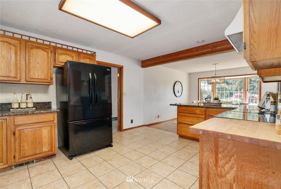 17002 Southeast 128th Street Renton, WA 98059 - Photo 11 of 30 a kitchen with stainless steel appliances granite countertop a refrigerator and a sink