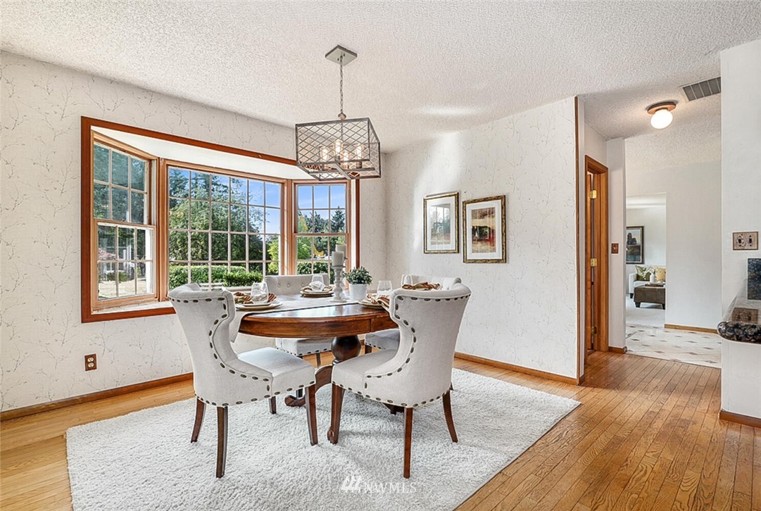 17002 Southeast 128th Street Renton, WA 98059 - Photo 7 of 30 a dining room with furniture a chandelier and wooden floor