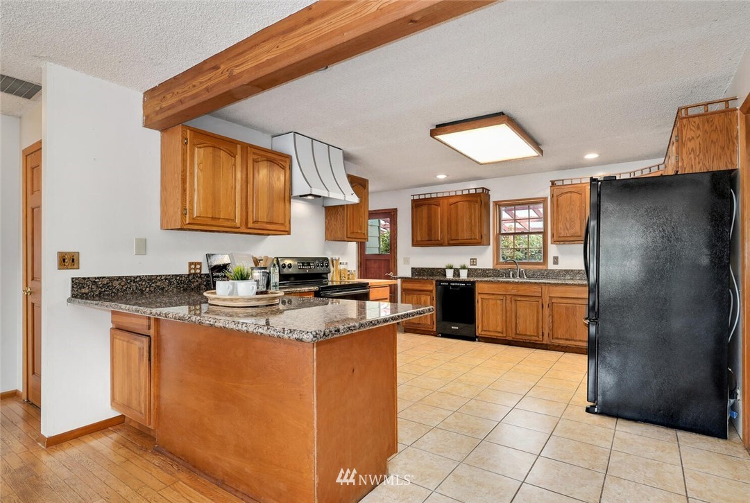 17002 Southeast 128th Street Renton, WA 98059 - Photo 8 of 30 a kitchen with stainless steel appliances granite countertop a sink stove and refrigerator