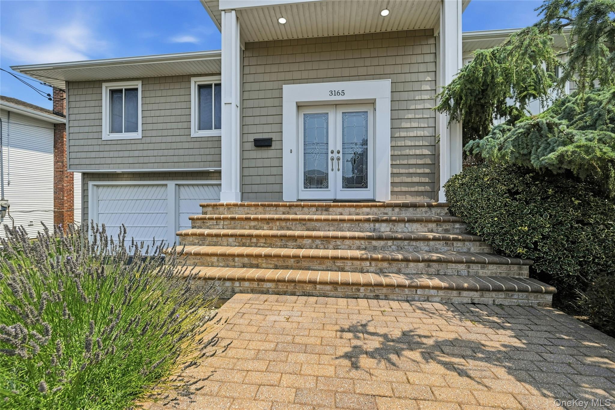 Paver stairs leading to double front door entry