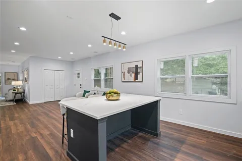 a view of a kitchen that has a sink a window and wooden floor