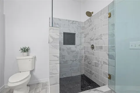 a bathroom with a toilet and a shower