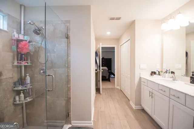 a spacious bathroom with a shower sink and mirror