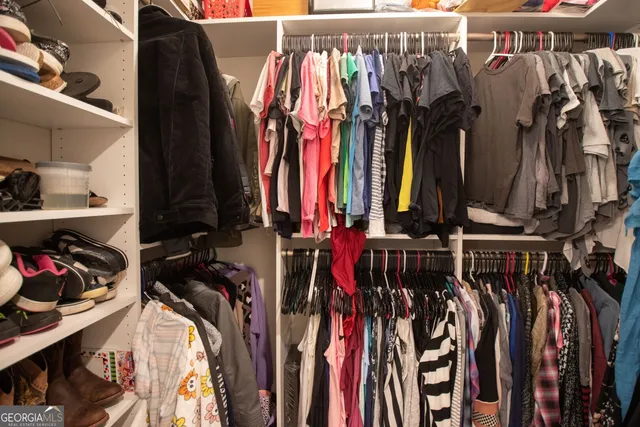 a view of walk in closet with clothes