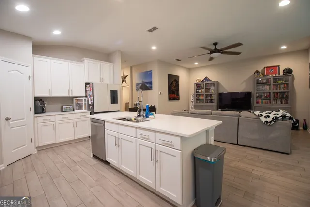 a kitchen with a sink a counter top space stainless steel appliances and cabinets