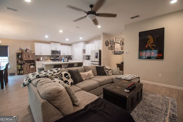 a living room with furniture kitchen view and a chandelier