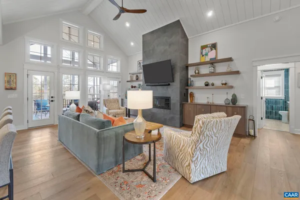 a living room with furniture a flat screen tv and kitchen view