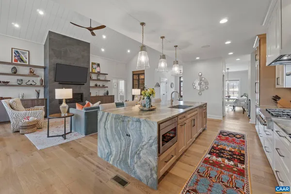 a large white kitchen with a large island oven a sink and stainless steel appliances