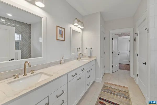 a spacious bathroom with double sink and a large mirror