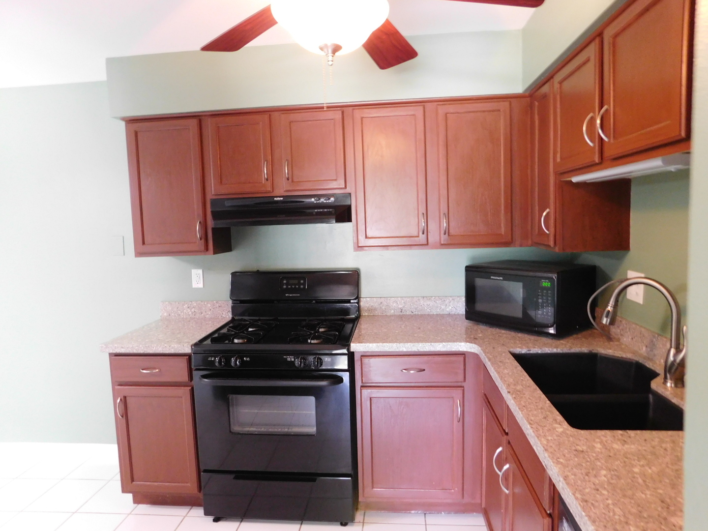 19398 Wolf Road, Unit 8 Mokena, IL 60448 - Photo 6 of 9 a kitchen with granite countertop wood cabinets stainless steel appliances and a sink